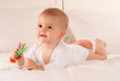Baby holding colourful pegs
