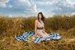 Beautiful slavonic girl on picnic in wheat field