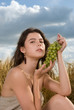 Beautiful slavonic girl on picnic in wheat field with grapes