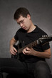 Man sitting and playing electric guitar