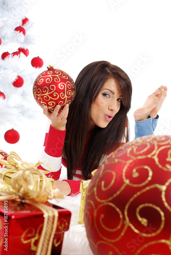 Beautiful girl with gift next to white christmas tree Beautiful girl with gift next to white christmas tree