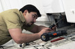 Foto: Man repairing dishwasher Man repairing dishwasher