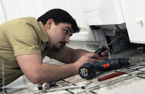 Photo: Man repairing dishwasher Man repairing dishwasher