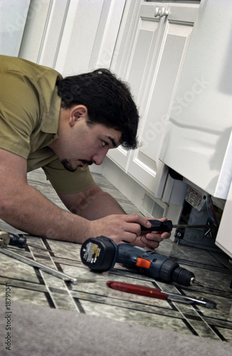 Photo: Man repairing dishwasher Man repairing dishwasher