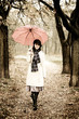 Girl with umbrella at park in rainy day. Photo in vintage style