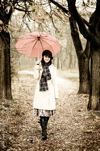 Photo: Girl with umbrella at park in rainy day. Photo in vintage style Girl with umbrella at park in rainy day. Photo in vintage style
