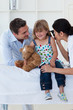 Female doctor checking smiling girl's ears