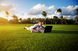 young man whith notebook on the green field