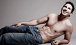 Lying muscular man looking at the left corner Lying muscular man looking at the left corner