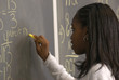 student writing math problem on chalkborad