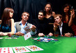 Stylish man in black suit folds two cards in casino
