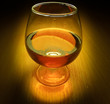 Glass of brandy with light on dark