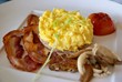 Crispy bacon scrambled eggs tomato and mushrooms for breakfast