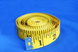 A coiled-like measuring tape isolated on blue