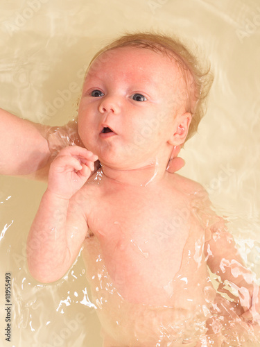 Photo: Bathin baby holded by hands. Bathin baby holded by hands.