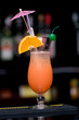 Fresh iced cocktail garnished orange and umbrella.