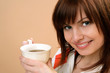 Portrait of young happy woman holding cup with tea