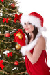 Christmas girl in santa hat with fir tree.