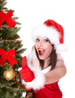 Christmas girl in santa hat and fir tree with  thumb up.