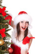 Christmas girl in santa hat point, fir tree. Isolated.