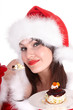Christmas girl in red santa hat and cake on plate.