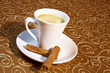 cup of coffee brown background with cinnamon stick