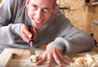 Young carpenter with gad working and smiling Young carpenter with gad working and smiling