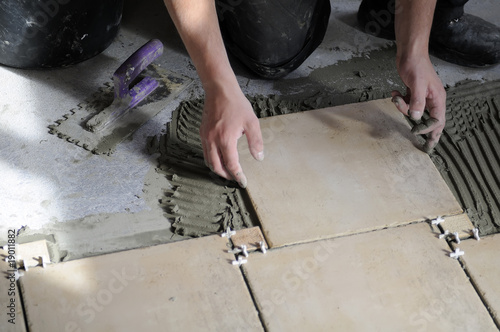 Photo: Closeup of tiles installation on the floor. Closeup of tiles installation on the floor.