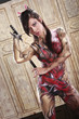 Asian girl in bodypainting with nunchuks