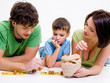 parents indoors playing with little son
