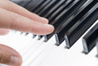 hand playing music on the piano