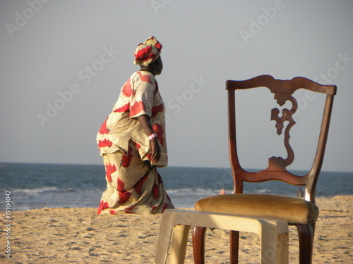 Photo: Mujer traje tipico de Gambia Africa en playa y silla Mujer traje tipico de Gambia Africa en playa y silla