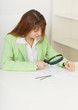 Young woman works with drawings by means of magnifier Young woman works with drawings by means of magnifier
