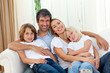 Foto: Smiling family relaxing on the sofa Smiling family relaxing on the sofa