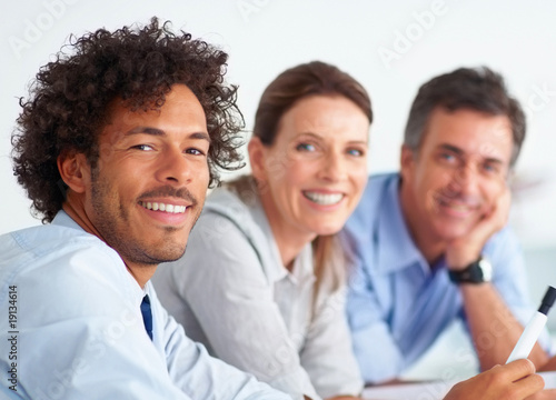Photo: Closeup of an African American business man at work, colleagues Closeup of an African American business man at work, colleagues