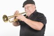 Mature man in flat cap playing the trumpet