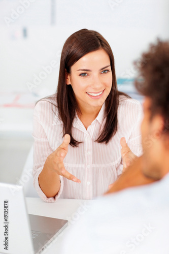 Foto: Elegant young magazine editor speaking with a colleague Elegant young magazine editor speaking with a colleague