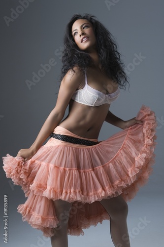 Photo: Woman stands in lace bra and peach coloured petticoat skirt Woman stands in lace bra and peach coloured petticoat skirt
