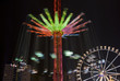 carousel and ferris wheel in an amusement park at night
