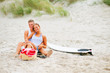 Cute young couple sitting together on the beach