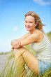 Cute young woman sitting calmly outdoors
