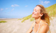 Cute young female enjoying the sunshine at the sea shore
