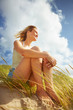 Upward view of a pretty young female sitting calmly outdoors