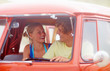 Happy young female besides her boyfriend travelling in a mini va