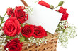 Red roses and blank card in wicker basket