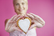 A Young Woman Holding Out A Heart Shaped Biscuit