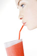 A Young Woman Drinking A Fruit Drink Through A Straw