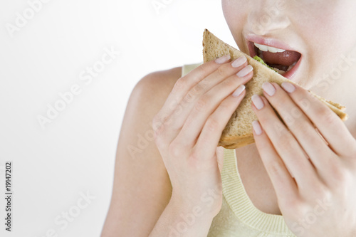 Photo: A Young Woman Eating A Sandwich A Young Woman Eating A Sandwich