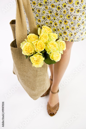 Photo: A Young Woman Carrying A Bunch Of Yellow Roses In A Shopping Bag A Young Woman Carrying A Bunch Of Yellow Roses In A Shopping Bag
