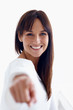 Happy female pointing at you isolated over white